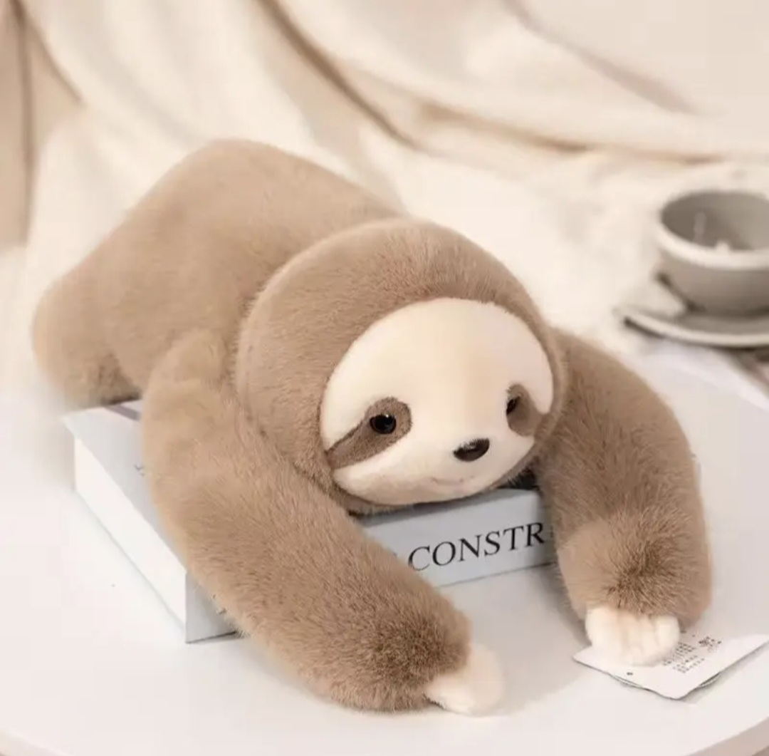 A happy customer hugging Ollie the weighted sloth on a couch